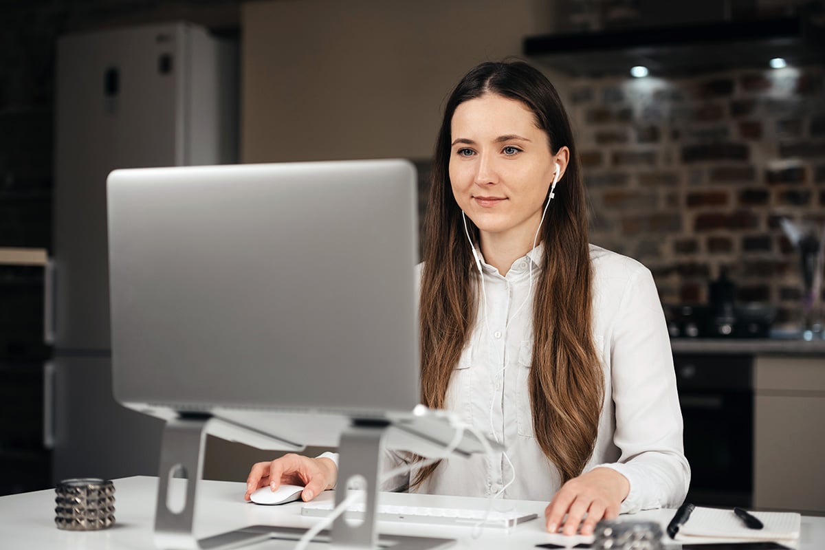 Woman looking at her laptop with earphones on