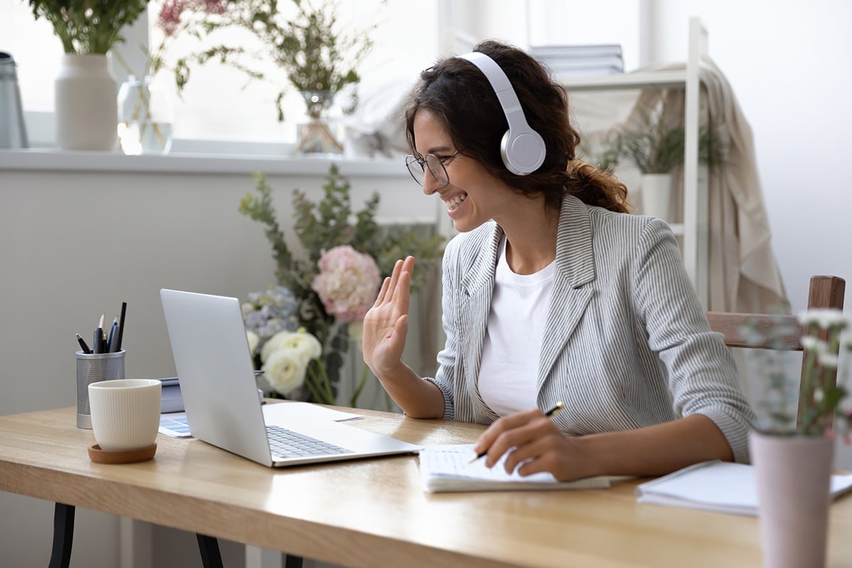 Woman excitedly waving at her laptop