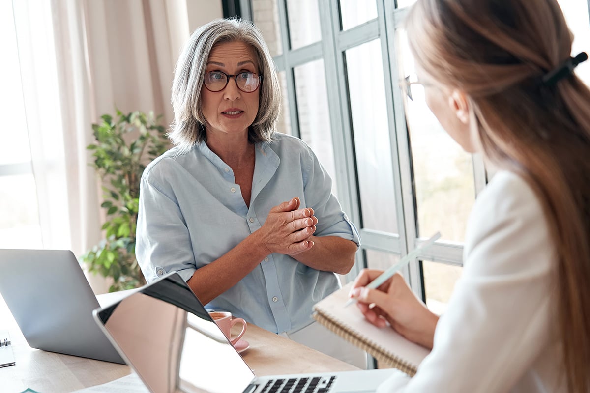 How to Be Selfish With Your Time, Without Being a Jerk: Woman talking to another woman with pen and pad