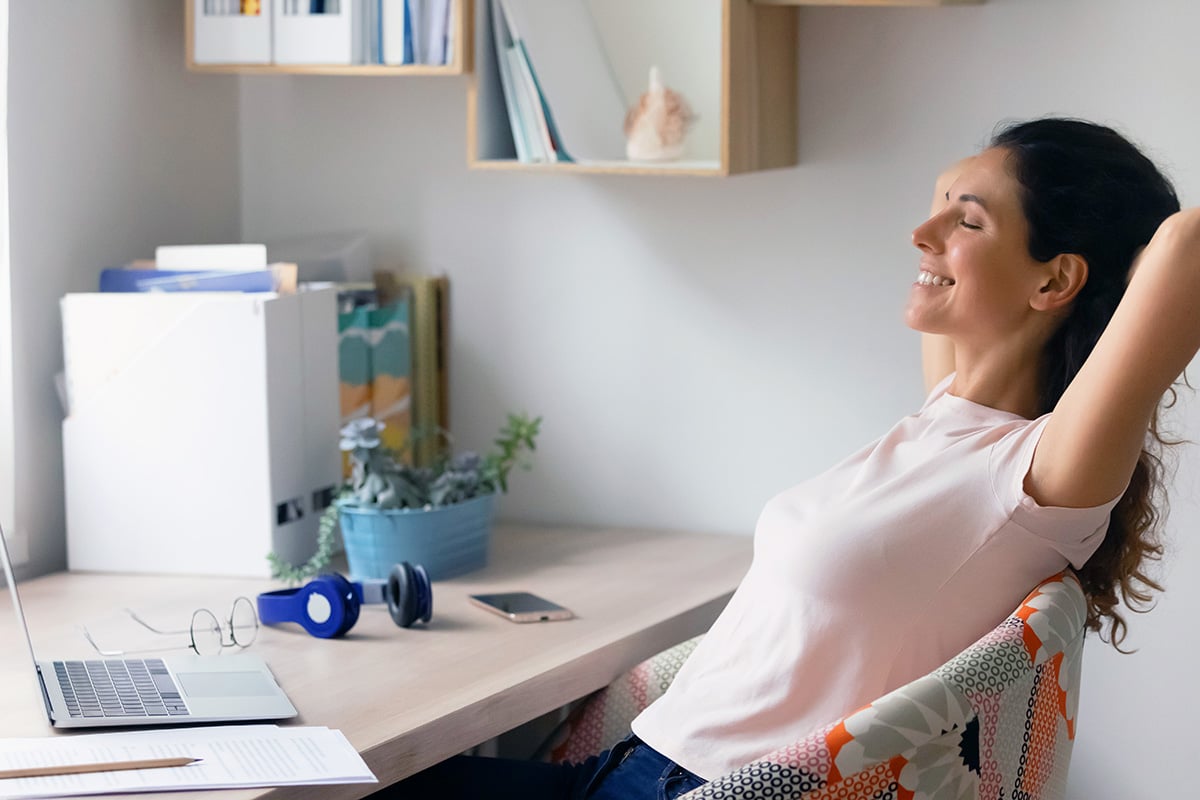 A woman leaning back on her chair and resting