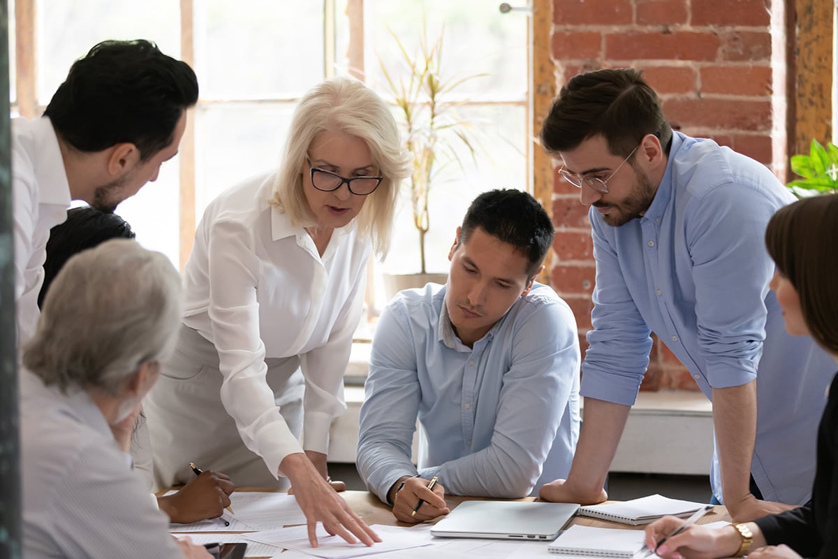 Group of employees gathered around a table working together