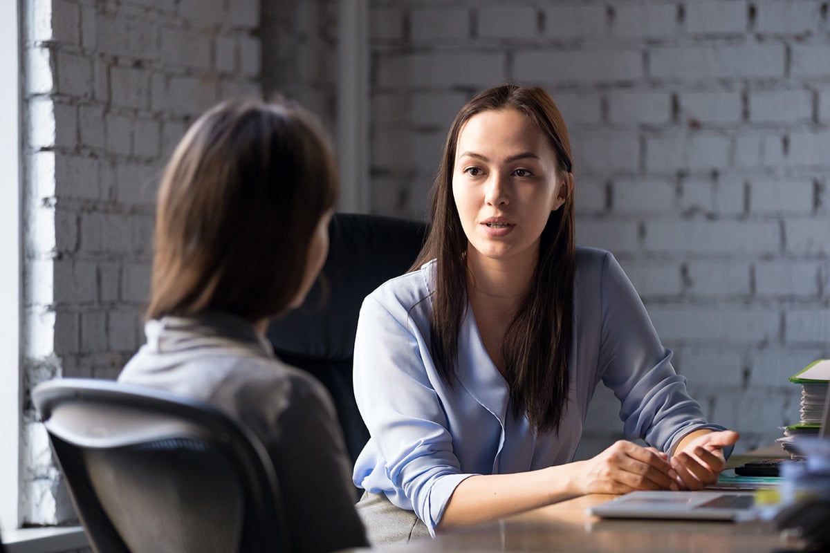 Two women talking in a professional setting